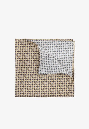 Jedwabny szalik z beżowym tłem, na którym powtarza się ciemnoniebieski wzór serc, z złożoną częścią odsłaniającą jasnoniebieskie tło z podobnymi sercami.