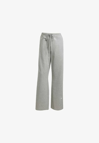 Svetlosivé tepláky vyrobené z mäkkého materiálu, s pružným pásom so šnúrkou, širokým strihom nohavíc a malým logom na dolnej časti ľavej nohavice.
