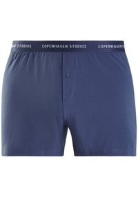 Herre boksershorts i mørk navy blå, lavet af blødt stof. Har en knaplukning og en elastisk talje med "Copenhagen Studios" branding.