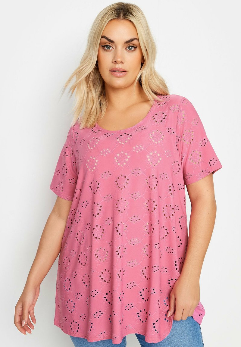 Top corto de manga corta en color rosa con un corte holgado, que presenta un patrón de recortes y un cuello redondo, hecho de una tela ligera. Estilo casual.