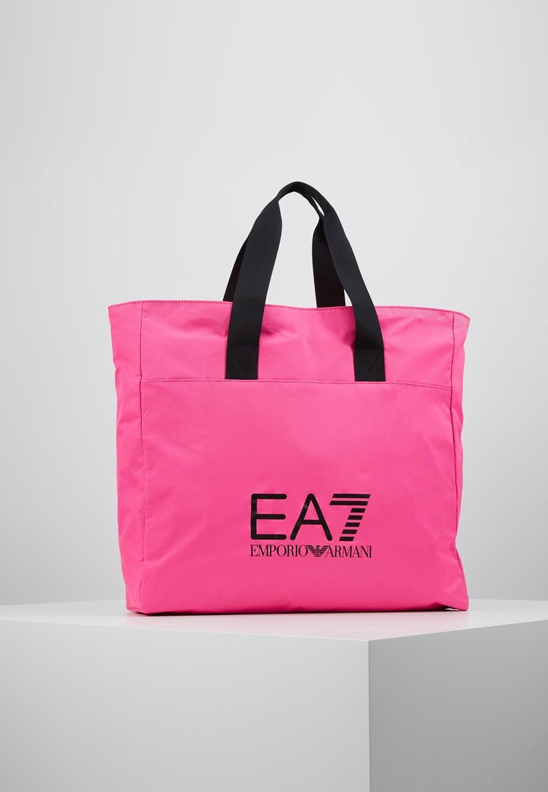 Růžová nylonová taška na rameno s černými držadly a potiskem loga "EA7 EMPORIO ARMANI" na přední straně. Má jednoduchý obdélníkový tvar.