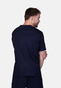 T-shirt in cotone blu navy con collo a giro, maniche corte e vestibilità comoda. Texture liscia senza motivi o dettagli decorativi visibili.