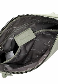 Sacchetto verde chiaro con zip, esterno testurizzato, interno grigio con un motivo discreto e scomparti multipli per l'organizzazione.