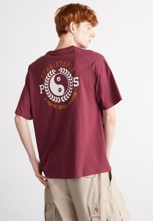 Burgunderfarget bomulls T-skjorte med et stort hvitt yin-yang og tekstdesign på baksiden. Korte ermer og avslappet passform.