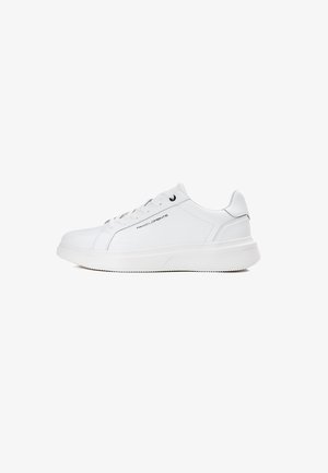 Białe sneakersy wykonane z gładkiej skóry, z okrągłym noskiem, płaskimi sznurówkami, grubą podeszwą i subtelnym logo z boku.
