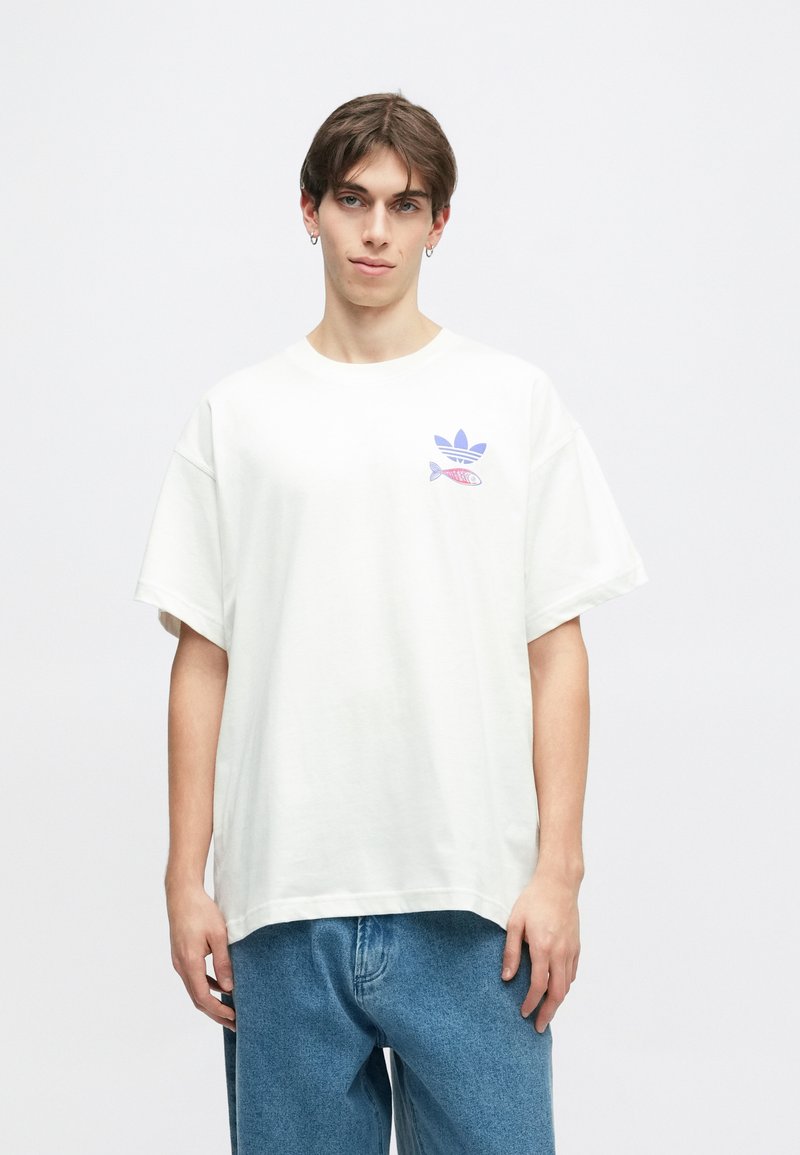 White cotton t-shirt with a round neck, short sleeves, and a large blue Adidas logo featuring a fish graphic on the left chest.
