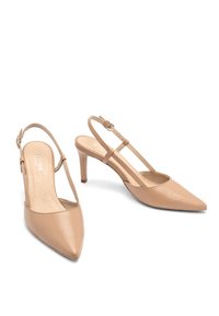 Nude leren slingback hakken met een puntige neus, slanke hak en verstelbare enkelband. Soepele textuur en minimalistisch ontwerp.