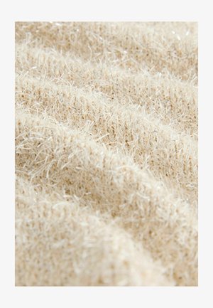 Texturovaná látka v béžové barvě s jemnými, třpytivými nitěmi. Materiál vypadá měkký a nadýchaný s mírně nerovným povrchem a variací hloubky.