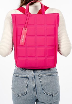 Roze rugzak van glanzend materiaal, met een gewatteerd ontwerp met vierkante patronen, bovenhandvatten en verstelbare schouderbanden voor het dragen.