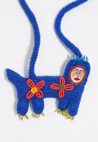 Bolso de ganchillo azul con forma de perro, adornado con flores de cuentas rojas y amarillas, una cara decorativa y patas de cuentas amarillas.