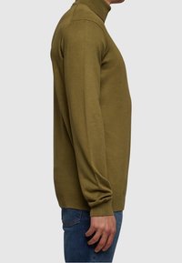 Olivegrüner Rollkragenpullover aus weichem Strickstoff, enger Schnitt, lange Ärmel sowie gerippte Bündchen und Saum.