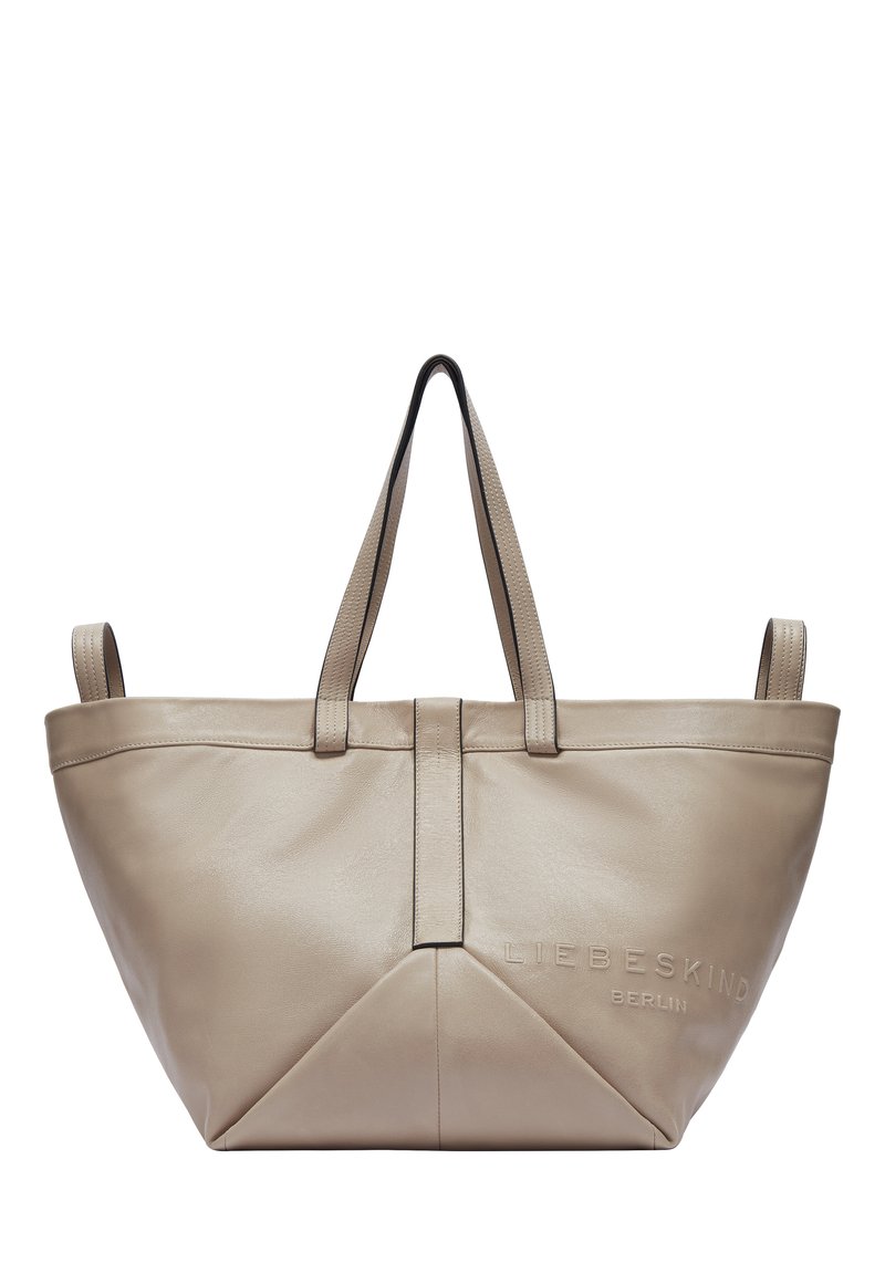 Beige Leder-Tote-Bag mit strukturiertem Design, ausgestattet mit zwei Griffen, Logo-Detail und einer dreieckigen Naht am Boden. Glatte Textur.