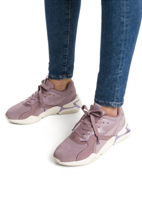 Ljuslila sportskor i mocka och mesh, med en tjock vit sula, snördesign och kontrasterande detaljer på hälen.