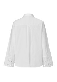 Chemise en coton blanc avec un col pointu, des manches longues agrémentées de broderie anglaise aux poignets, et un pli central au dos pour un détail de design supplémentaire.