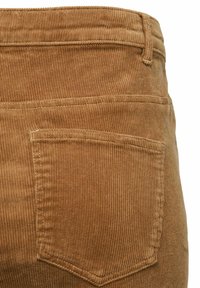 Tessuto in corduroy marrone, caratterizzato da un motivo a costine testurizzato, con una cucitura visibile della tasca posteriore e dettagli di cucitura.