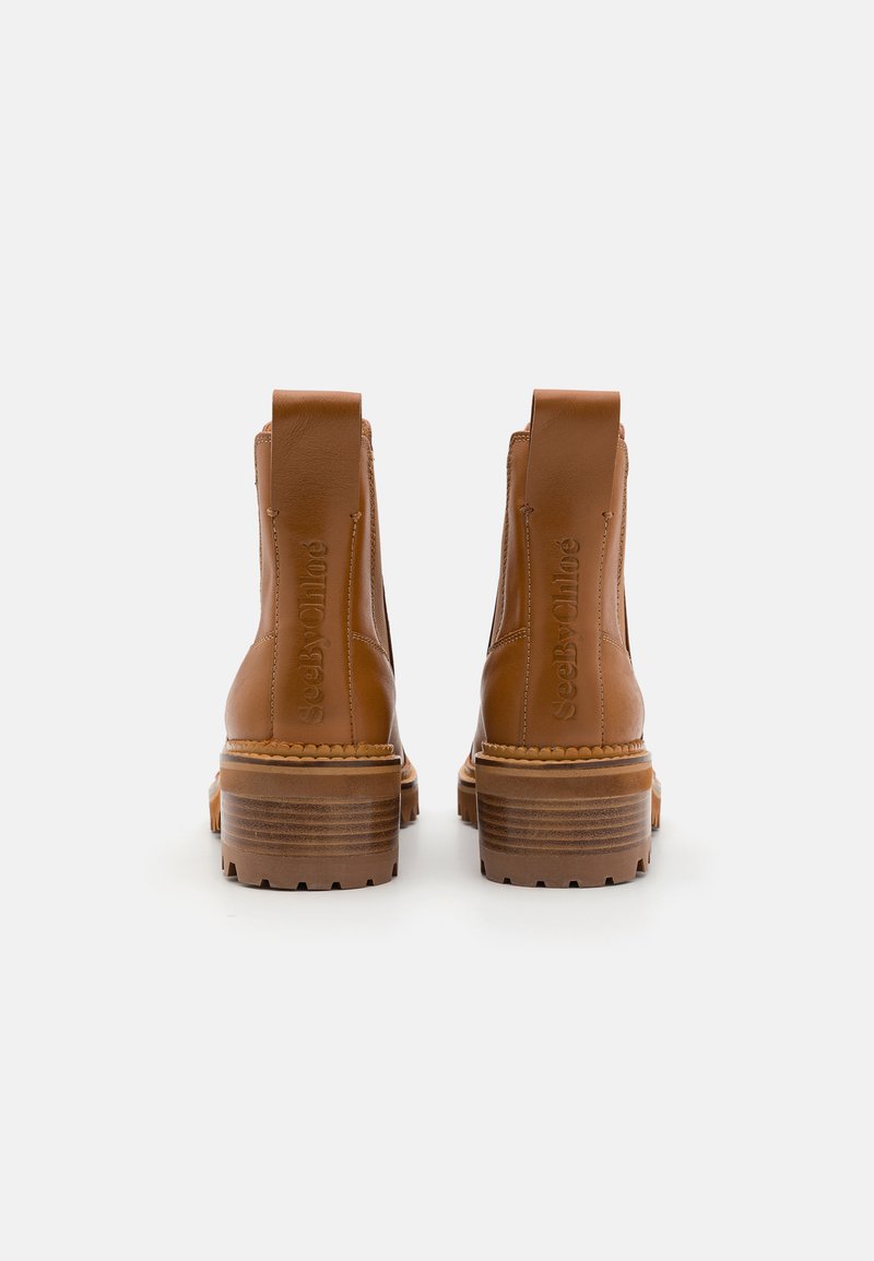 Stivali alla caviglia in pelle marrone con finitura testurizzata, tacco impilato e linguette per la presa. "See By Chloé" inciso sul retro.