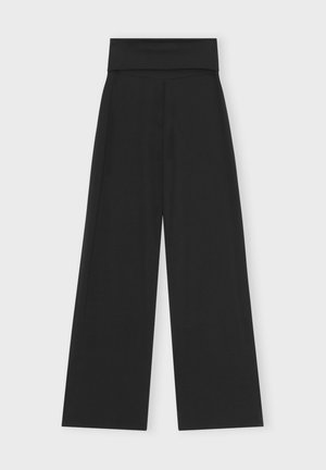 Wide-leg black pants with a thick waistband, smooth texture, and minimalist design. No visible fastenings or additional patterns.