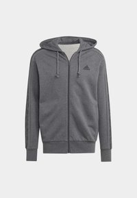 Pelēks pilna ar gultas kapuci, ar aukliņu, Adidas logo uz krūtīm un smalkām svītrām, kas skrien gar piedurknēm.