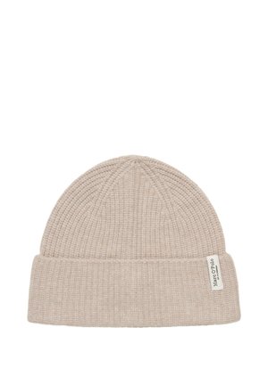 Bonnet tricoté beige avec une texture côtelée, doté d'un revers plié et d'une petite étiquette de marque sur le côté.
