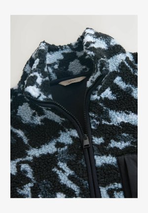 Fleecejacke mit einem schwarzen und hellblauen abstrakten Muster, hohem Kragen und Frontreißverschluss. Verfügt über ein glattes Futter und eine strukturierte Außenseite.