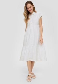 Witte katoenen midi-jurk met een kraag, korte mouwen, knoopdetails en een gelaagde rok met subtiele textuur en perforaties.