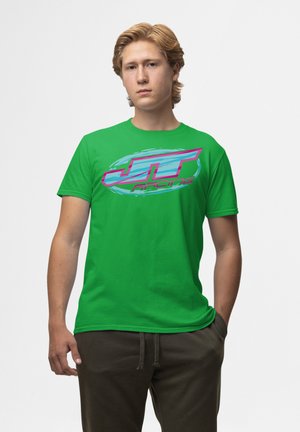 Grøn bomulds t-shirt med et stort pink og blåt "JT Racing" logo med et cirkulært design. Rund hals og korte ærmer.