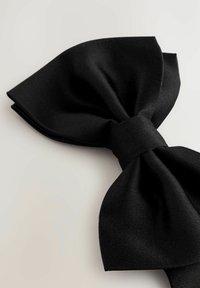 Papillon nero realizzato in tessuto strutturato, caratterizzato da una forma ampia ed elegante con pieghe pronunciate e un nodo centrale liscio.