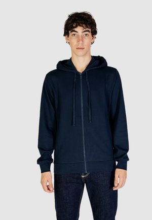 Mørkeblå zip-up hættetrøje med snoretræk i huen, ribbede manchetter og en glat tekstur. Sammen med mørk denim jeans. Enkel og funktionel design.