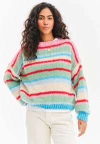 Sweter dziany o fakturze, w pastelowych kolorach, z paskami zieleni, różu, czerwieni i niebieskiego. Szerokie rękawy i luźny fason.