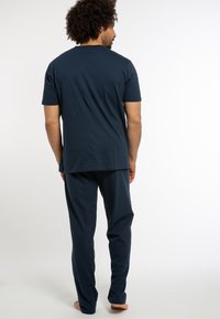 Navy Baumwoll-Loungewear-Set mit einem T-Shirt mit kurzen Ärmeln und passender Hose. Der Stoff wirkt weich mit einer glatten Textur und lässiger Passform.