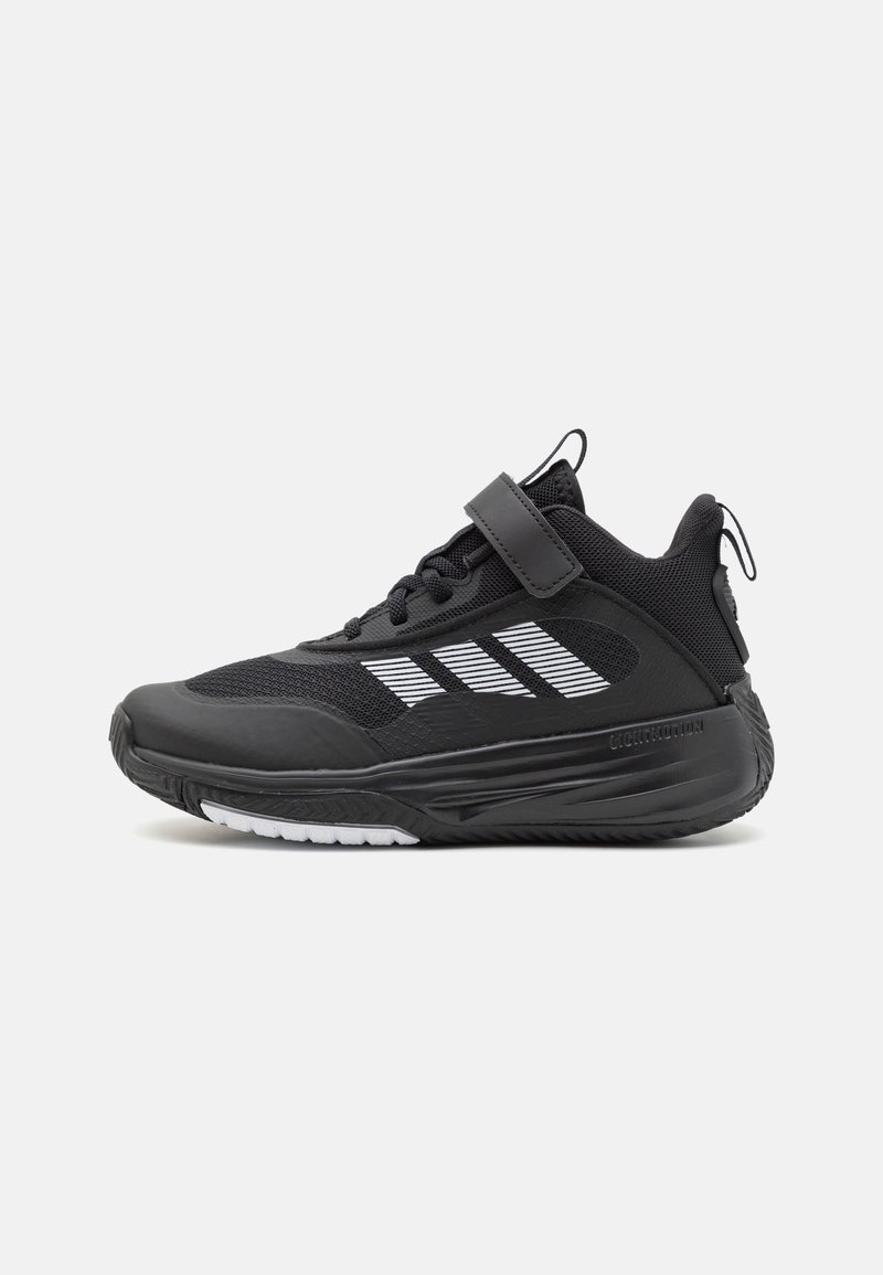 Schwarzer Sportschuh mit Obermaterial aus Mesh, Gummisohle und weißen Streifen. Verfügt über einen Klettverschluss und strukturierte Akzente für besseren Halt.