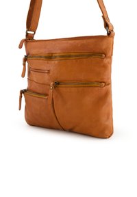Sac en cuir marron à bandoulière avec plusieurs poches zippées, une texture lisse et une sangle réglable pour un transport facile.