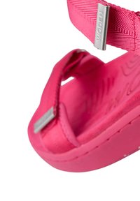 Ljusrosa sandal med strukturerade remmar, gummibas och en logotags. Har en justerbar rem och en dämpad fotbädd för komfort.