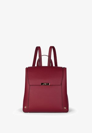 Červený kožený batoh s dvěma ramenními popruhy, horním uchopěním, přední klapkou a malou zlatou logovou destičkou.