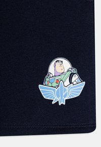 Navy puuvillane t-särk, millel on prinditud graafika astronaudist roheline ja hall värviga siniste aktsentidega ning lennuki embleem all.