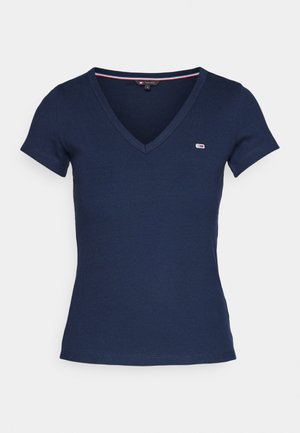 Camiseta de V con cuello en color azul marino, de manga corta, con textura acanalada y un pequeño logo en el lado izquierdo del pecho. Presenta un detalle de contraste en el interior del cuello.