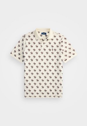 Polo en coton beige, présentant un motif répété de petits cavaliers colorés. Col classique et manches courtes.