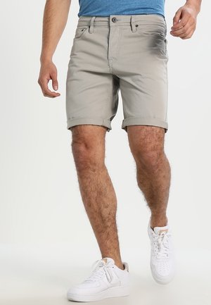 Grijze katoenen shorts met omgeslagen pijpen, een aansluitend ontwerp en voorzakken, gedragen met een blauw T-shirt en witte sneakers.