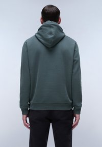 Hoody in gedempt groene stof, met een relaxte fit, geribbelde manchetten en een effen achterkant zonder zichtbare branding.