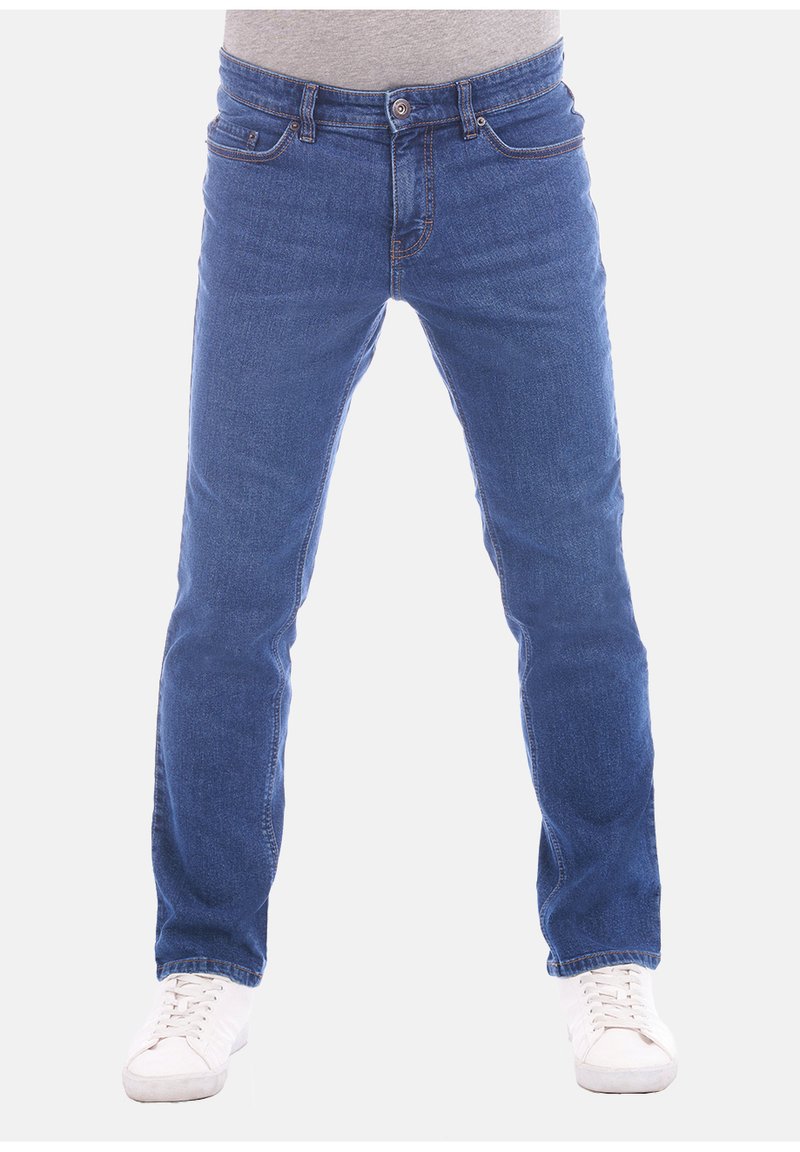 Jeans in denim blu con taglio dritto, design a cinque tasche e dettagli di cucitura in evidenza, abbinati a sneakers bianche.