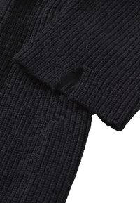 Schwarzer gerippter Strickpullover mit locker sitzenden Ärmeln und einem Ausschnitt, der die Textur und das Design aus mehreren Schichten zeigt.