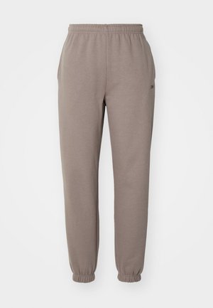 Pantaloni della tuta marroni in un tessuto morbido, con vita elasticizzata, orli a coste e tasche laterali. Branding discreto sulla coscia.