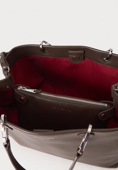 Sac à main en cuir marron avec des ferrures argentées, montrant une doublure intérieure rouge et une pochette intérieure zippée.
