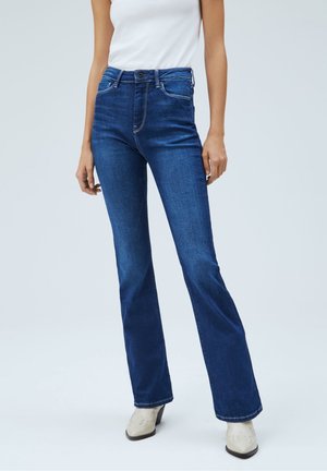 Vaqueros de campana en denim azul oscuro, con cintura de altura media, cinco bolsillos, costuras blancas y detalles de botones metálicos. Textura suave con un ligero estiramiento.