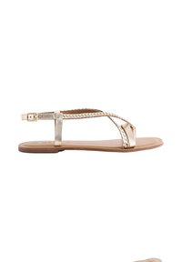 Sandalo in ecopelle dorata con cinturini intrecciati, suola piatta e fibbia regolabile alla caviglia. Design minimalista con finitura liscia.