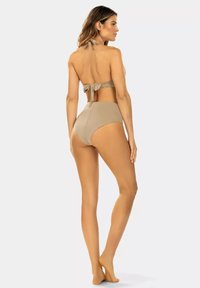 Beżowy dwuczęściowy bikini z topem na halterach, z wiązanym z tyłu. Wysokie majtki o gładkim wykończeniu i bezszwowej konstrukcji.