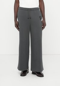 Γκρι φόρμες με άνετη εφαρμογή, ελαστική μέση με κορδόνι, πλαϊνές τσέπες και διακοσμητικό με λουλουδάτο σχέδιο στο αριστερό πόδι. Λείο, απαλό ύφασμα.