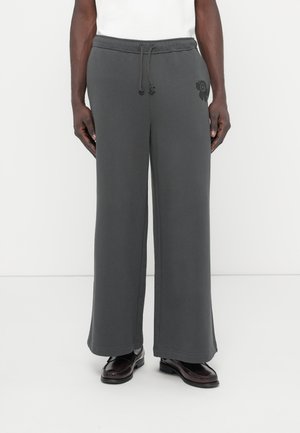 Γκρι φόρμες με άνετη εφαρμογή, ελαστική μέση με κορδόνι, πλαϊνές τσέπες και διακοσμητικό με λουλουδάτο σχέδιο στο αριστερό πόδι. Λείο, απαλό ύφασμα.