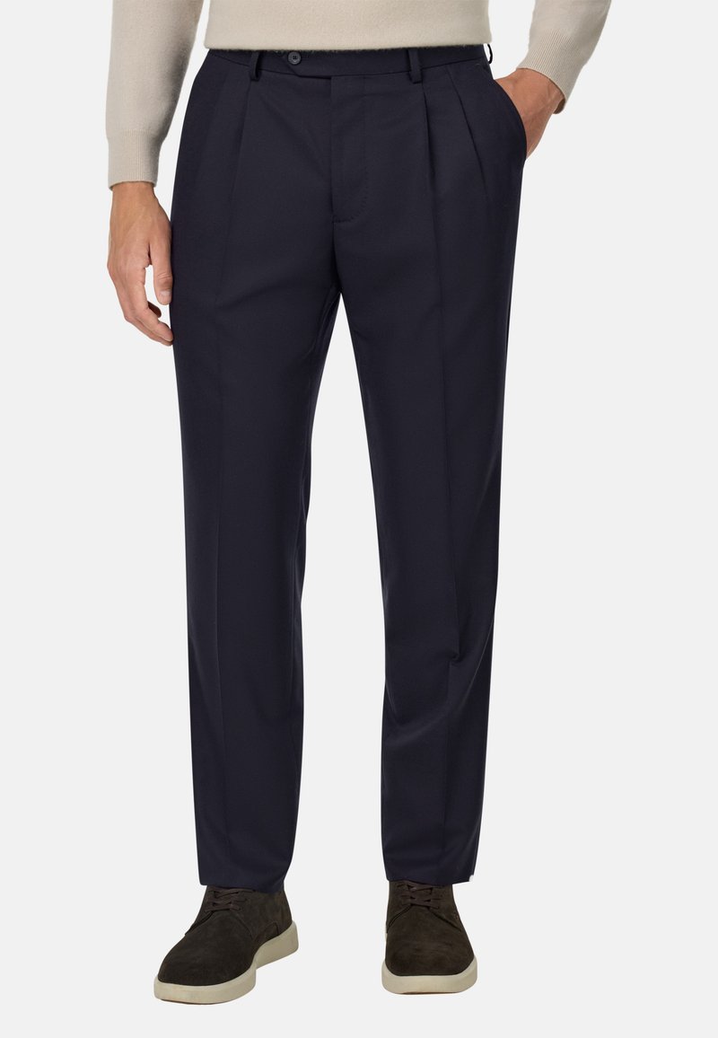 Jūras flotes stila bikses no gludas auduma, ar priekšējiem krokām, standarta jostasvietu un sānu kabatām. Valkātas ar tumšām kurpēm.