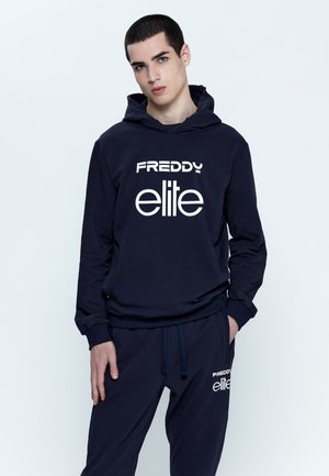 Completo di felpa con cappuccio e pantaloni della tuta blu navy con il testo bianco "FREDDY elite". Presenta un cappuccio regolabile e polsini elasticizzati. Tessuto morbido e casual.